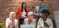 Shot of a group of businesspeople sitting together in a meeting. Group of people on a business meeting.  Aged businesswoman, teacher or business coach speaking to young people